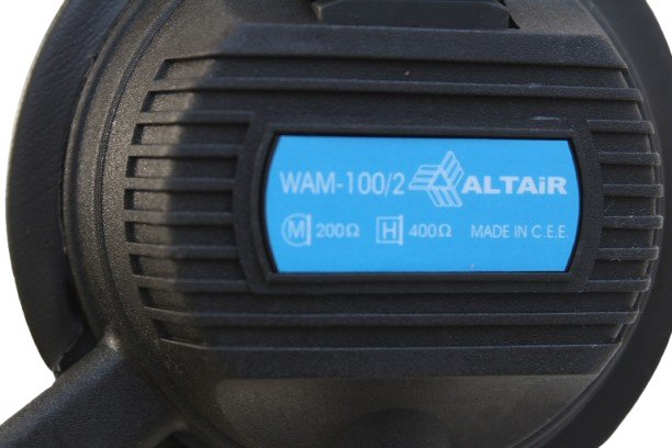Close-up of a headset earshell with a blue label featuring 'WAM-100/2' and 'ALTAIR'.